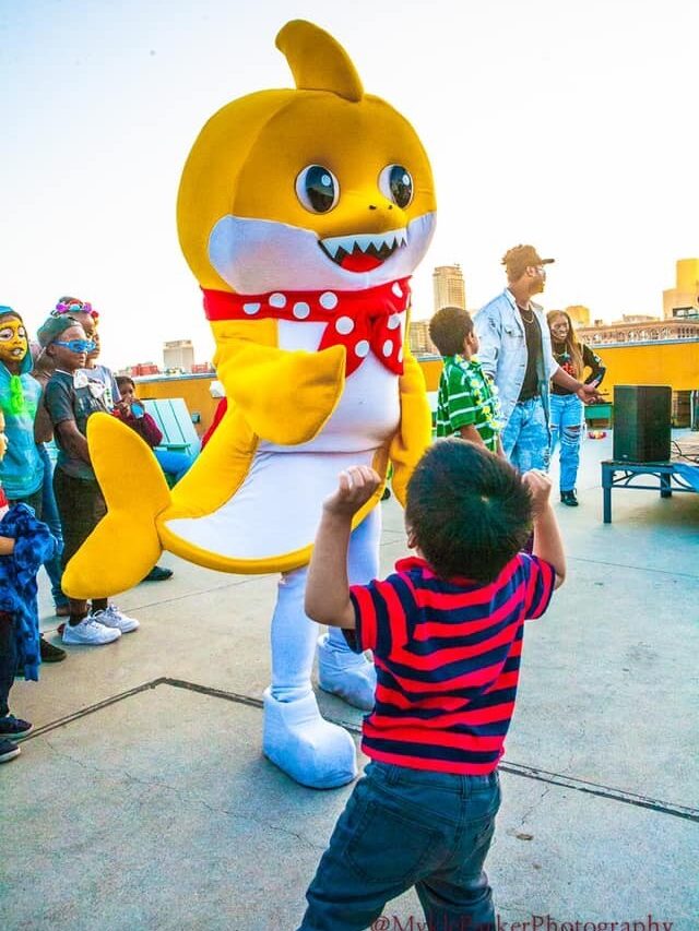 Baby Shark dancing with a boy wearing a striped shirt